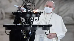 Le Pape François allume une bougie lors d'une cérémonie interreligieuse sur la place du Campidoglio, à Rome, le 20 octobre 2020. / Vatican Media