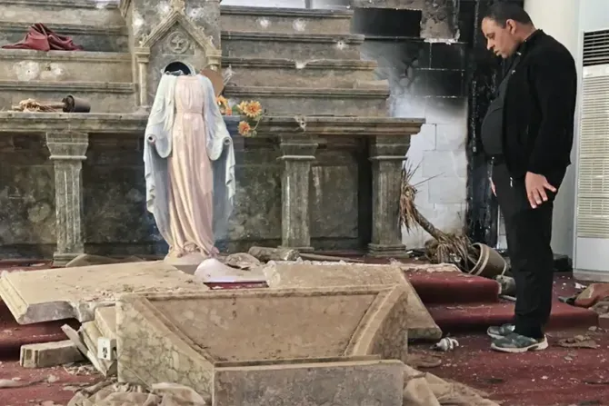 Un prêtre examine les dégâts causés par ISIS dans une église catholique à Karamles, en Irak. | Crédit photo : Photo avec l'aimable autorisation de Stephen Rasche / 