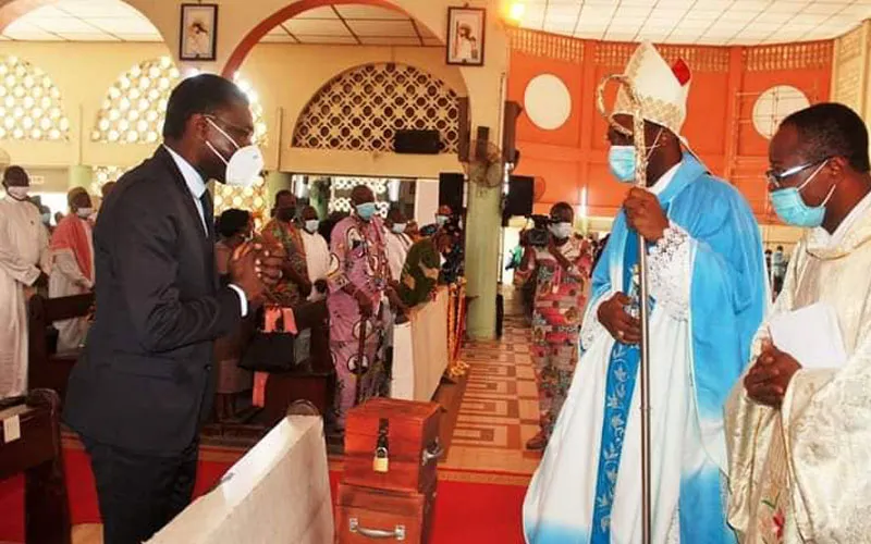 Mgr Roger Houngbédji salue le président du Conseil constitutionnel du Bénin, Joseph Djogbenou, lors de l'office de prière à la cathédrale Notre-Dame de la Miséricorde, dans l'archidiocèse de Cotonou.