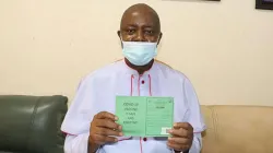 Mgr Callistus Valentine Onaga, du diocèse catholique d'Enugu au Nigeria, tient son carnet de vaccination après avoir reçu le vaccin COVID-19. / 