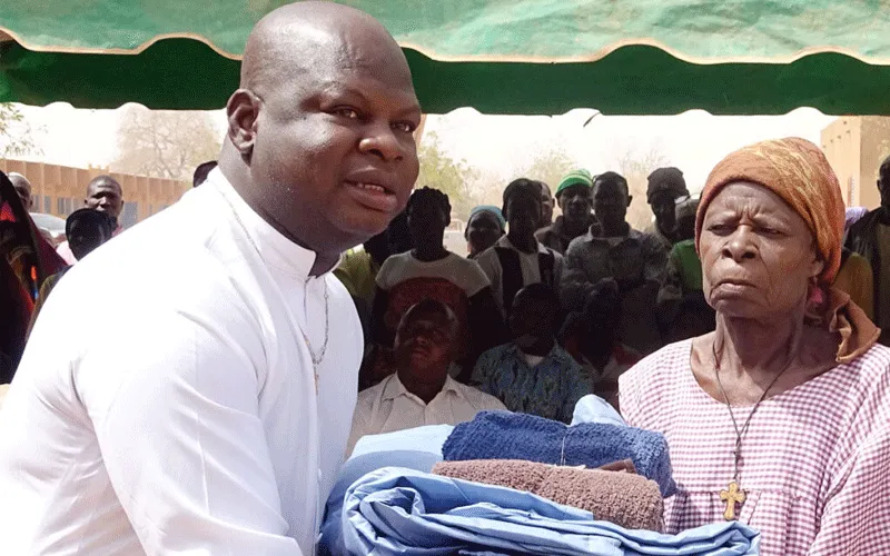 Un bienfaiteur remet des vêtements à une femme déplacée au Burkina Faso. Caritas Burkina Faso