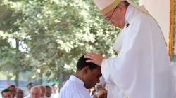 Le pape François impose les mains à un diacre bangladais alors qu'il l'ordonne à la prêtrise lors d'une messe du 1er décembre 2017 à Dhaka. Vatican Media. / 