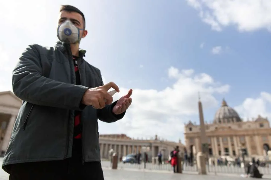 Un pèlerin de Russie porte un masque et utilise du désinfectant pour les mains devant la basilique Saint-Pierre au Vatican le 6 mars 2020. Daniel Ibáñez/CNA.