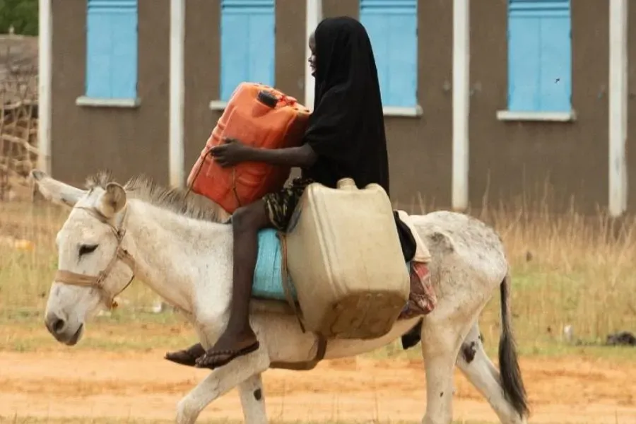 Une fille transportant de l'eau dans le camp de réfugiés de Djabal, au Tchad. Crédit : JRS
