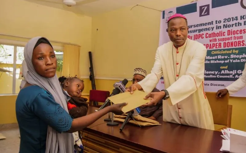 Mgr Stephen Dami Mamza remettant la somme de 150 000 Naira à l'une des victimes de l'insurrection de Boko Haram. Crédit : Diocèse de Yola