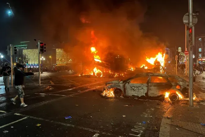 Des flammes s'élèvent d'une voiture et d'un bus incendiés à la jonction de Bachelors Walk et du pont O'Connell, à Dublin, le 23 novembre 2023, alors que les gens sont descendus dans la rue à la suite des agressions à l'arme blanche survenues plus tôt dans la journée. | Crédit : Peter Murphy/AFP via Getty Images
