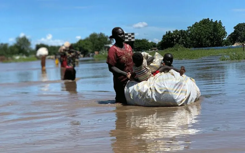 Les fortes pluies et les graves inondations qui se sont abattues sur le Sud-Soudan la semaine dernière ont causé d'importants dégâts dans les camps de réfugiés et de personnes déplacées. Des milliers de personnes, comme cette mère et ses enfants, ont été forcées de chercher un terrain plus élevé. Service jésuite des réfugiés.