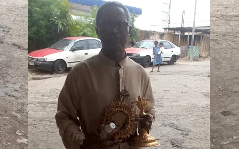Le Père Benoît Dieme avec l'ostensoir et la lunule contenant le corps du Christ retourné à la paroisse de Rois Mages, à Akebe Ville, dans l'archidiocèse de Libreville au Gabon. Domaine public