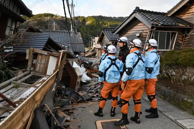 Des pompiers inspectent des maisons en bois effondrées à Wajima, dans la préfecture d'Ishikawa, le 2 janvier 2024, au lendemain d'un important séisme de magnitude 7,6 qui a frappé la région de Noto dans la préfecture d'Ishikawa. | Crédit photo : KAZUHIRO NOGI/AFP via Getty Images