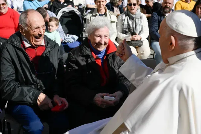 Le pape François salue un couple de personnes âgées lors de l'audience générale sur la place Saint-Pierre au Vatican. / 