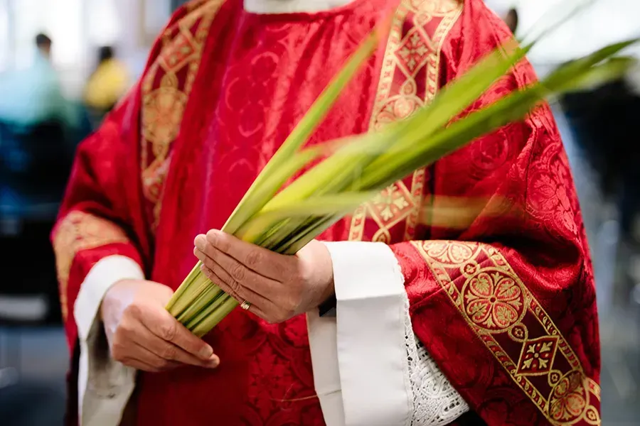 Un prêtre tient des palmes le dimanche des Rameaux.