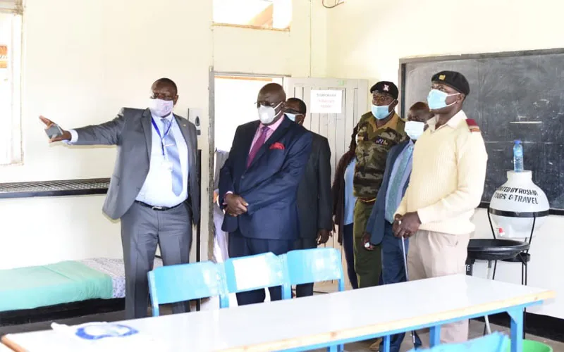 Le secrétaire d'État à l'éducation du Kenya, George Magoha, inspecte une pièce aménagée par l'équipe de Heri Healthcare pour le traitement des élèves d'une école kenyane. Heri Healthcare