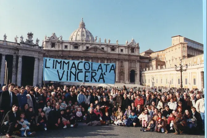 La communauté de la Maison de Marie pose pour une photo le 8 décembre 1994, sur la place Saint-Pierre, la première fois qu'ils ont apporté leur bannière bleue avec les mots "L'Immaculée Conception triomphera" à l'Angélus avec le Pape Jean-Paul II. Le groupe a continué à apporter la bannière à l'Angélus chaque dimanche pendant 29 ans. | Crédit : Comunita Casa di Maria