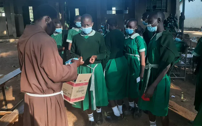 Le Père Stephen Otieno Makagutu donne des serviettes hygiéniques aux filles de l'école primaire St. Dominic Kianja dans l'archidiocèse de Kisumu Crédit : Père Stephen Otieno Makagutu