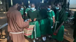 Le Père Stephen Otieno Makagutu donne des serviettes hygiéniques aux filles de l'école primaire St. Dominic Kianja dans l'archidiocèse de Kisumu Crédit : Père Stephen Otieno Makagutu / 
