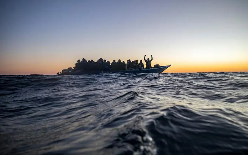 Les migrants sur un bateau surpeuplé attendent de l'aide.