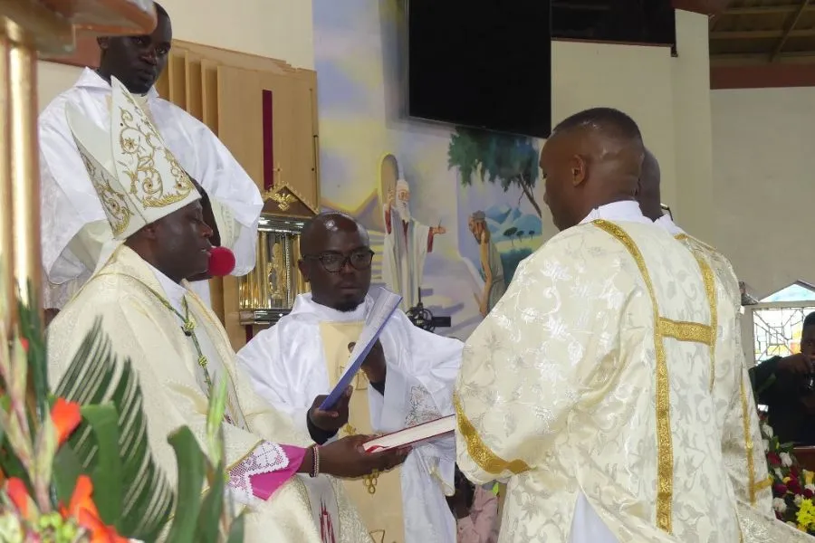 Mgr John Mbinda présente le Livre des Évangiles aux diacres nouvellement ordonnés. Crédit : ACI Afrique
