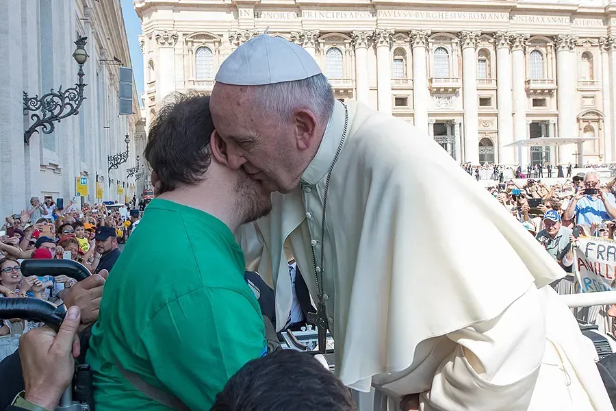 Le pape François embrasse un homme en fauteuil roulant lors de l'audience générale du mercredi sur la place Saint-Pierre, le 10 juin 2015. L'Osservatore Romano.