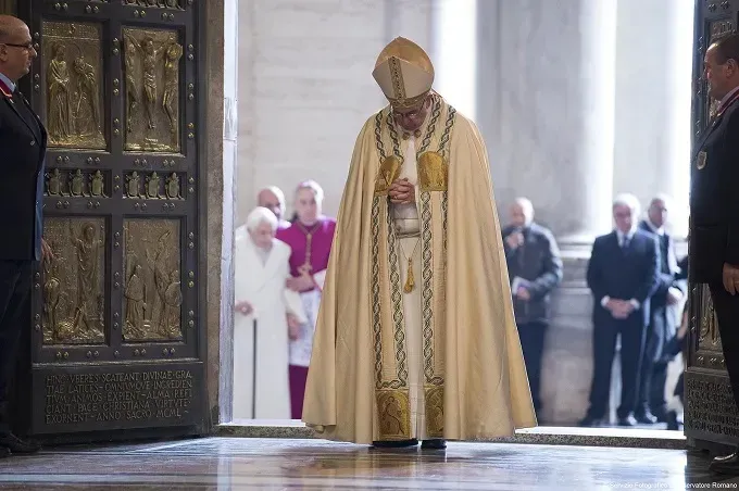 Le pape François prie après l'ouverture de la Porte Sainte dans la basilique Saint-Pierre, le 8 décembre 2015, lançant le jubilé extraordinaire de la miséricorde. LOsservatore Romano.