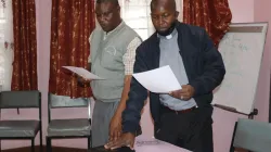Le nouveau président du RSCK, le père Robert Karanja Ireri (à droite) et le vice-président, le frère Placid Kaburu (à gauche) prêtent serment peu après leur élection le 14 octobre lors de l'assemblée générale annuelle du RSCK à Nairobi. / 
