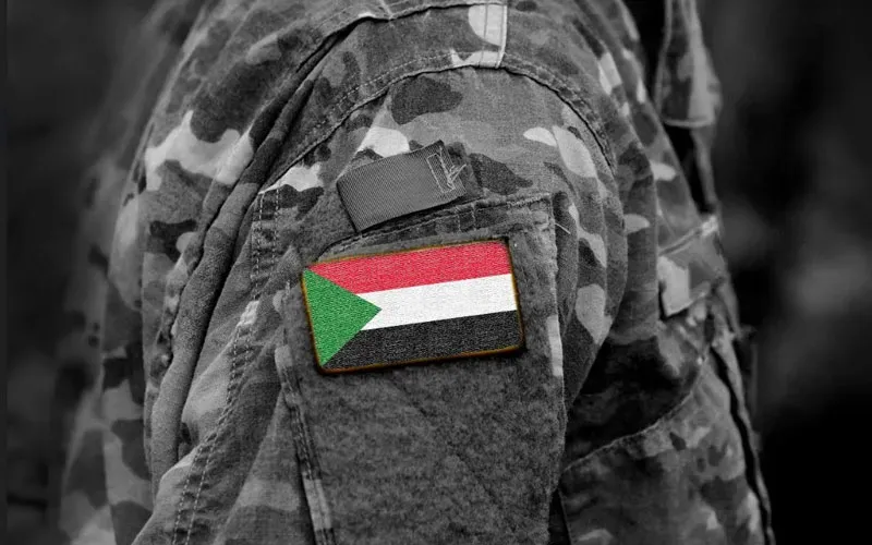 Le drapeau du Soudan sur le bras d'un soldat. Crédit : Bumble Dee/Shutterstock / 