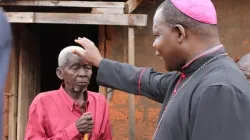 Le Cardinal Dieudonné Nzapalainga bénissant un homme âgé. Crédit : AED / 